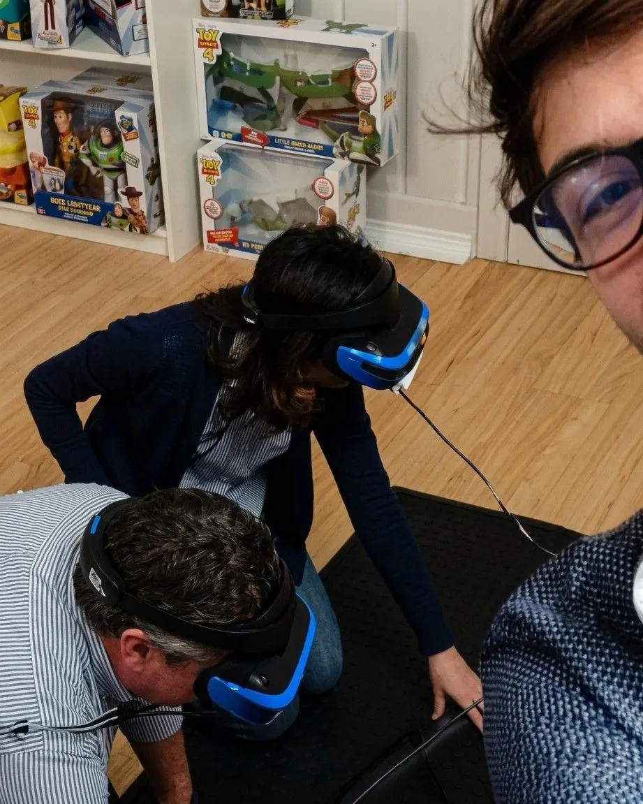 Due persone con il visore si chinano con le vertigini durante una demo in realtà virtuale