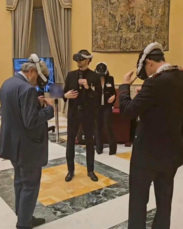 Più persone provano con il visore una demo di realtà virtuale in una sala istituzionale