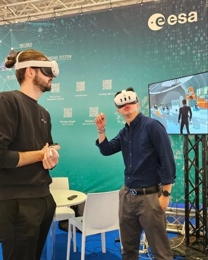 Due persone provano con il visore una demo di realtà virtuale a uno stand fieristico