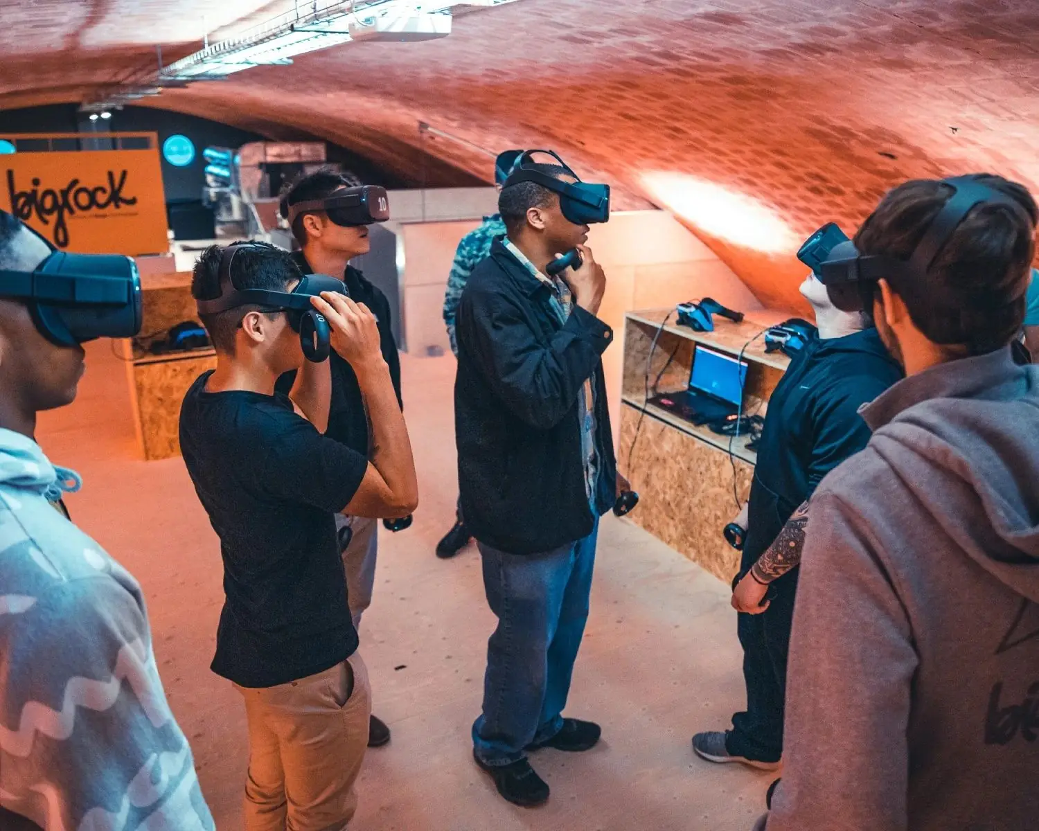 Un gruppo di persone con il visore dentro la stessa esperienza di realtà virtuale, in una sala con il soffitto a volta